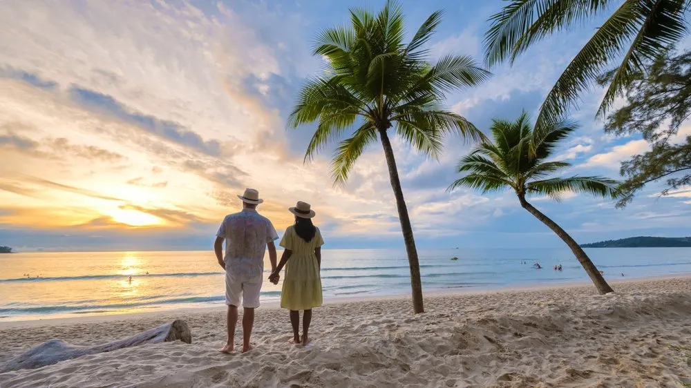 https://www.andamandaphuket.com/sites/andamanda/files/inline-images/A%20couple%20takes%20in%20a%20romantic%20sunset%20while%20holding%20hands%20on%20a%20beach%20in%20Phuket.jpg